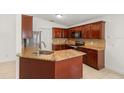 Updated kitchen with granite countertops, stainless steel appliances, and wooden cabinets at 1914 Ellery Ln, Kissimmee, FL 34746