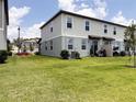 Spacious backyard featuring lush green grass and the rear of the two-story home at 2086 Crape Jasmine Ln, Orlando, FL 32824