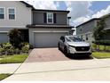 Modern home featuring a brick-paved driveway and a spacious two-car garage at 2086 Crape Jasmine Ln, Orlando, FL 32824