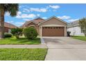 Charming single-Gathering home with a well-manicured lawn, lush landscaping, and a two-car garage at 2912 Lazlo Ln, Orlando, FL 32837