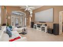 Spacious living room with high ceilings, tile floors, media center, and French doors to the lanai at 2912 Lazlo Ln, Orlando, FL 32837
