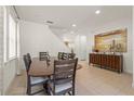Bright dining room with a large wooden table, tan tile floors and a decorative painting at 340 Pendant Ct, Kissimmee, FL 34747