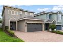 Beautiful home with a brick driveway, two-car garage, and manicured bushes at 340 Pendant Ct, Kissimmee, FL 34747