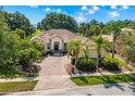 Aerial view of a single-story home showcasing a brick driveway, lush landscaping and beautiful tile roof at 3427 Harborside Ct, Kissimmee, FL 34746
