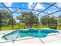 Screened-in pool area with turquoise pool water and view of the lush backyard at 3427 Harborside Ct, Kissimmee, FL 34746
