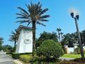 Community entrance featuring a palm tree and white sign at 4800 Riverwalk Dr, St Cloud, FL 34771