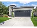 Front exterior of house with a two-car garage, an inviting walkway, and a gray roof at 4903 Santa Clara Dr, Orlando, FL 32837