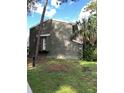 Side view of a two-story home with green siding and minimal landscaping, featuring a tree shading the side at 5826 Peregrine Ave # F01, Orlando, FL 32819