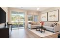 Bright living room featuring a contemporary sofa, large windows, and sliding glass doors to the exterior at 746 Lake Dell Ave, Dundee, FL 33838