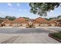 Street view of coordinated townhomes each featuring two car garages and tile roofs at 7667 Sugar Bend Dr # 7667, Orlando, FL 32819