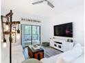 Bright living room with white sofas, rustic decor, and sliding doors to a screened patio at 9055 Treasure Trove Ln # 207, Kissimmee, FL 34747