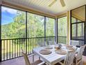 Relaxing screened patio featuring a dining table with comfortable seating and beautiful wooded views at 9055 Treasure Trove Ln # 207, Kissimmee, FL 34747