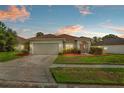 Charming single-story home with a well-maintained lawn and two-car garage at 906 Berwick Dr, Davenport, FL 33897