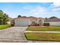 Charming single-story home with a well-maintained lawn and two-car garage at 906 Berwick Dr, Davenport, FL 33897