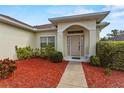 Close-up of the front entrance with walkway and landscaped garden at 906 Berwick Dr, Davenport, FL 33897