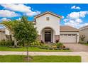Inviting home exterior with stone accents, lush landscaping, paver driveway, and a barrel tile roof at 13809 Abberwick Dr, Orlando, FL 32832