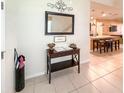 Inviting foyer with tile flooring, a stylish table, and view to the open kitchen at 1876 Summer Dr, Davenport, FL 33897