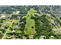 An aerial view reveals a large property amid a mix of trees and homes in a sprawling neighborhood at 1886 Pleasant Hill Rd, Kissimmee, FL 34746