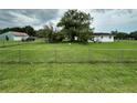 Spacious, grassy yard with a chainlink fence surrounds this single-Gathering home at 1886 Pleasant Hill Rd, Kissimmee, FL 34746