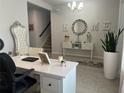 Well-appointed home office featuring a decorative mirror, accent furniture, and natural lighting at 1896 Basenji Dr, Lake Alfred, FL 33850