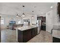 Open-concept kitchen featuring an island with a sink and views into the living area at 1951 Partin Terrace Rd, Kissimmee, FL 34744