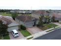 Aerial view of a home with a tile roof and brick driveway in a sunny residential community at 2016 Lakeside Ave, Davenport, FL 33837