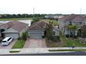 Aerial view of home featuring brick driveway, tile roof, lush landscaping and lake views at 2016 Lakeside Ave, Davenport, FL 33837