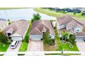 Aerial view of a single-Gathering home with a clay tile roof, brick driveway, and lush green lawn at 2016 Lakeside Ave, Davenport, FL 33837