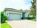 Charming single-Gathering home features a gray 2-car garage, clay tile roof, and brick driveway at 2016 Lakeside Ave, Davenport, FL 33837