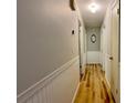 Hallway with wood floors, white molding, and neutral-colored walls at 2127 Patrick St, Kissimmee, FL 34741