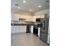 Modern kitchen with white cabinets, stainless steel appliances, and tile flooring at 254 Mandovi St, Davenport, FL 33837