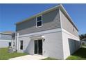 Backyard view showing the sliding glass door and neutral-toned siding with a white trim at 2863 Big Sur Rd, Davenport, FL 33837