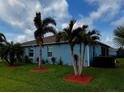 Exterior view of the blue single-story home with well-maintained lawn and palm trees at 2919 Woodward Ln, Winter Haven, FL 33884