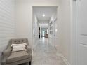 Inviting hallway with neutral walls, tile floors, and an accent chair at 3052 Prelude Ln, Kissimmee, FL 34746