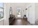 Bright foyer with hardwood floors and decorative console table at 3224 Oxbow Ct, Harmony, FL 34773