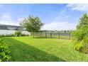 Expansive backyard with lush green grass, fenced-in yard, and lake view at 3424 Middlebrook Pl, Harmony, FL 34773