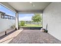 Covered patio featuring brick flooring with a scenic view of the backyard and lake at 3424 Middlebrook Pl, Harmony, FL 34773