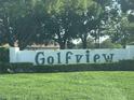 Community entrance sign surrounded by a green lawn and foliage at 416 Howard Ave # D, Lakeland, FL 33815