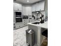 Beautiful kitchen featuring updated cabinets, stainless steel appliances, and a modern island with a black faucet at 426 Cardinal Ct, Kissimmee, FL 34759