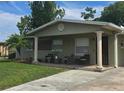 Inviting front porch featuring classic column supports, with seating area, and a well kept front yard at 4520 W Oak Ridge Rd, Orlando, FL 32809