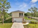 View of house with two-car garage, walkway and fenced backyard at 4899 Meadow Dr, St Cloud, FL 34772