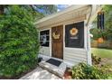 Close-up of a charming front door, adorned with decorative wreaths and a cheerful sunflower sign at 517 Carolina Ave, St Cloud, FL 34769
