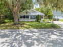 Well-maintained single-story home with a lush green lawn and mature trees creating a picturesque setting at 517 Carolina Ave, St Cloud, FL 34769