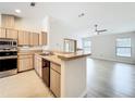 Bright kitchen with wood cabinets, stainless steel appliances, and an open layout to the living area at 5452 Higgins Way, Orlando, FL 32808