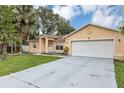 Charming single-story home with a well-manicured lawn and attached two car garage at 600 Regency Way, Kissimmee, FL 34758
