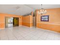 Open living area with tile flooring and a chandelier light fixture above at 600 Regency Way, Kissimmee, FL 34758