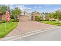 Beautiful single-story home with a brick driveway, well-maintained landscaping, and stone facade details at 726 Irvine Ranch Rd, Kissimmee, FL 34759