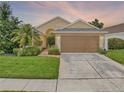 Charming single-Gathering home showcasing a well-manicured lawn and a two-car garage at 737 Oxford Dr, Davenport, FL 33897