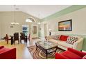 Bright living room with high ceilings, wood floors, stylish furniture, and a formal dining area at 737 Oxford Dr, Davenport, FL 33897
