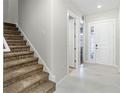 Bright entryway features neutral paint, tile floors, plush carpet stairs, and white trim at 7554 Sunflower Cir, Kissimmee, FL 34747